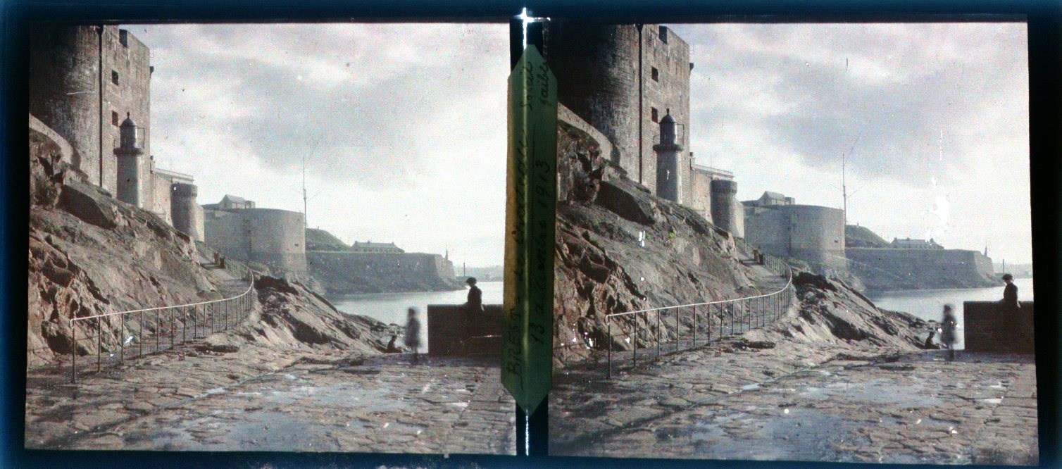 1913 color stereoscopic view of the Château de Brest with the harbor-light tower at the castle foot.