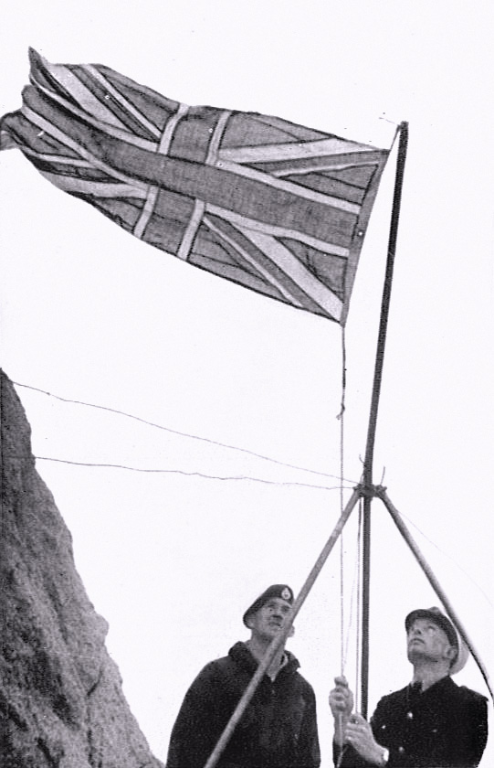 Royal Navy personnel raising the Union Flag on Rockall in 1955.